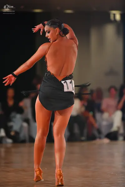 Dancesport competitor #11: Female dancer: black latin dress with an open back and thin straps, paired with 