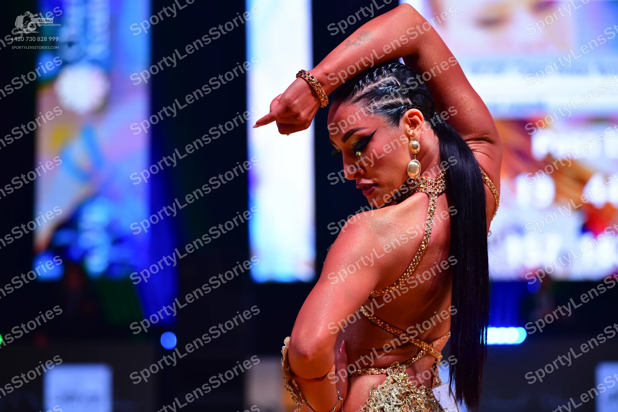 Dancesport competitor: Female dancer: gold-colored, heavily sequined Latin dance costume with a backles