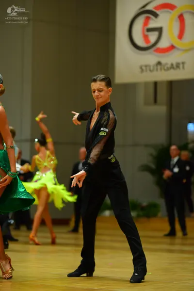Dancesport competitor: Male dancer: black long-sleeved shirt with sheer mesh panels and black trousers