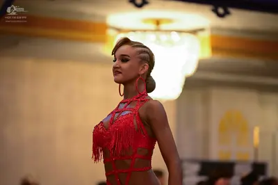 Dancesport competitor: Female dancer: red latin dress with red fringe, red straps, and large red hoop e