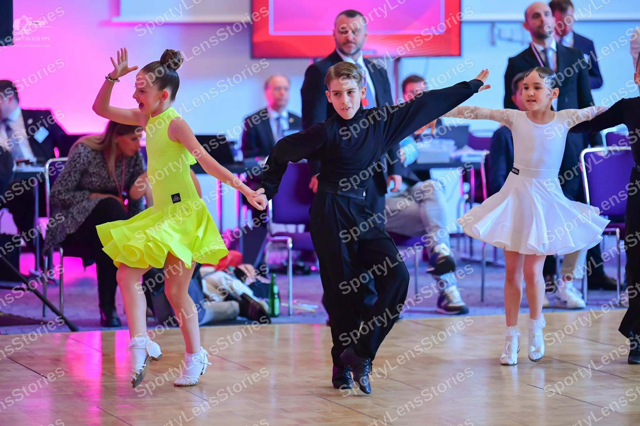 Dancesport competitor: Female dancer (left): yellow latin dress, sleeveless, short flared skirt