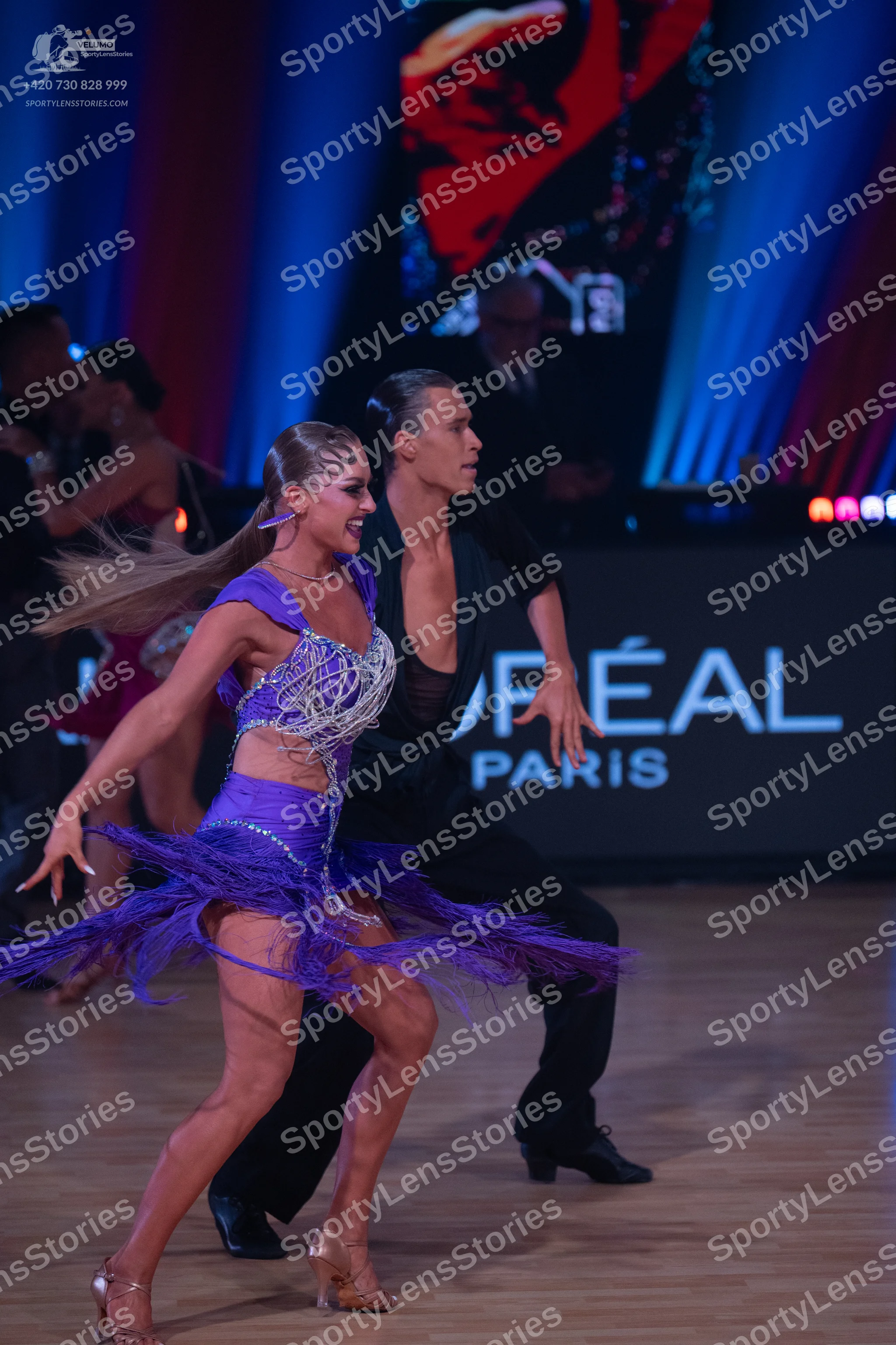 Dancesport competitor: Female dancer: purple Latin dress with sequins and fringe