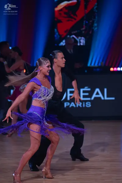 Dancesport competitor: Female dancer: purple Latin dress with sequins and fringe
