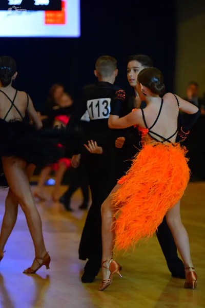 Dancesport competitor #113: Female dancer (left): black latin dress with thin straps and an X-back design