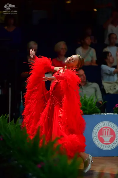Dancesport competitor: Female dancer: red latin dress with red feather trim