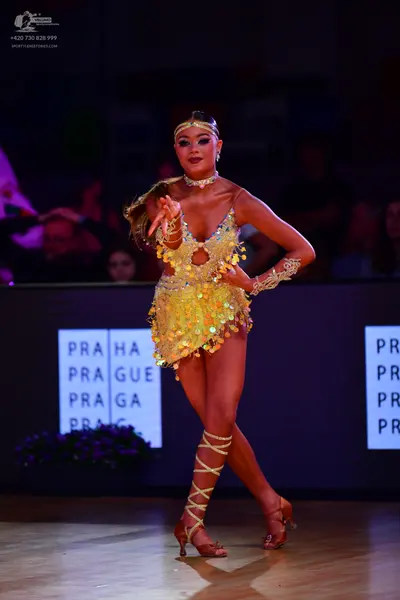 Dancesport competitor: Female dancer: gold sequin Latin dance dress with long sleeves and cut-outs, gol