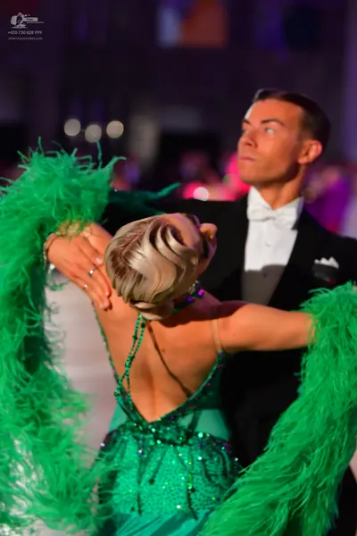 Dancesport competitor: Male dancer: black tuxedo with a white shirt, white bow tie, and a white pocket 