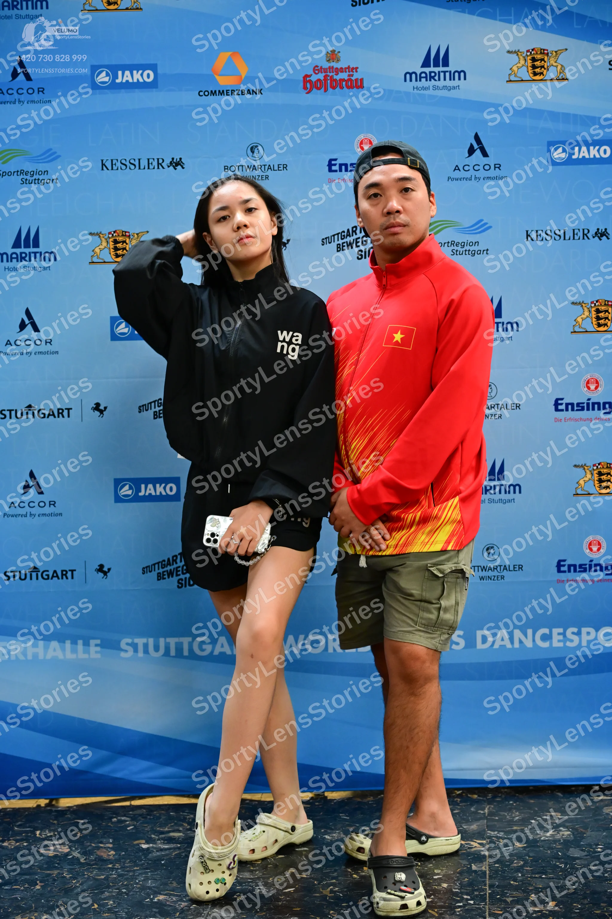 Dancesport competitor: Female dancer: black zip-up jacket with white "wang" text and black shorts