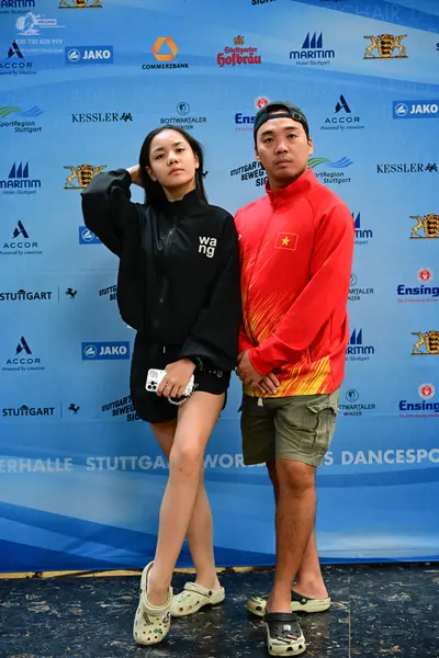 Dancesport competitor: Female dancer: black zip-up jacket with white "wang" text and black shorts