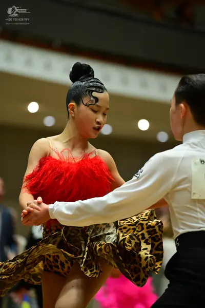 Dancesport competitor: Female dancer: red latin dress with a red fringe bodice and a leopard print ruff