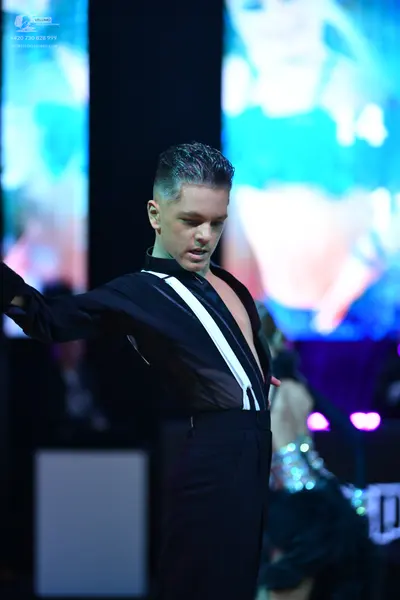 Dancesport competitor: Male dancer: black long-sleeved shirt with a white diagonal stripe detail