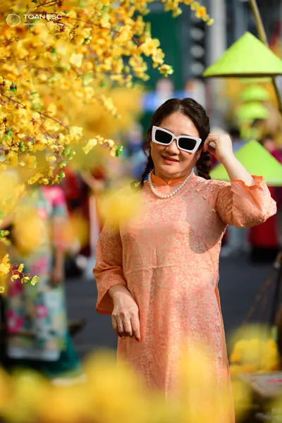 Dancesport competitor: Female dancer: peach-colored, long-sleeved dress with a subtle floral brocade pa