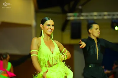 Dancesport competitor: Female dancer: lime green Latin dance dress with fringe and matching armbands