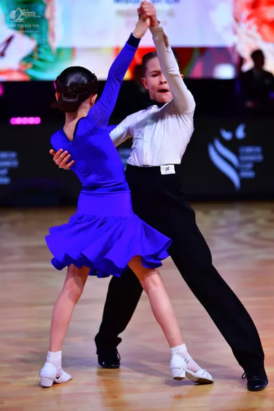 Dancesport competitor: Male dancer: white long-sleeved shirt and black trousers