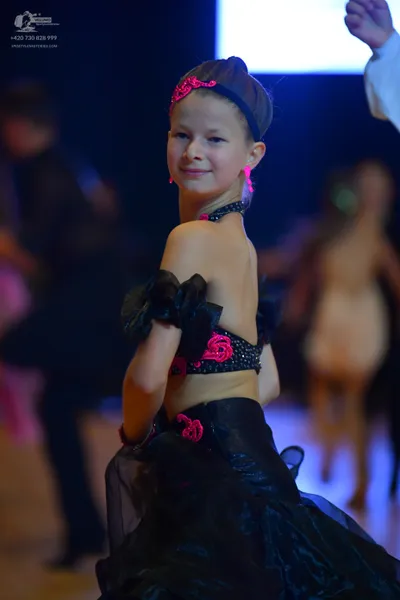 Dancesport competitor: Female dancer: black ballroom dress with pink/magenta sequin/beaded floral accen