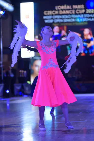 Dancesport competitor: Female dancer: neon pink latin dress with silver sequin embellishments on the bo