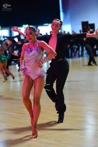 Dancesport competitor: Female dancer: light pink/lavender sequined Latin dress with long, thin, sparkli