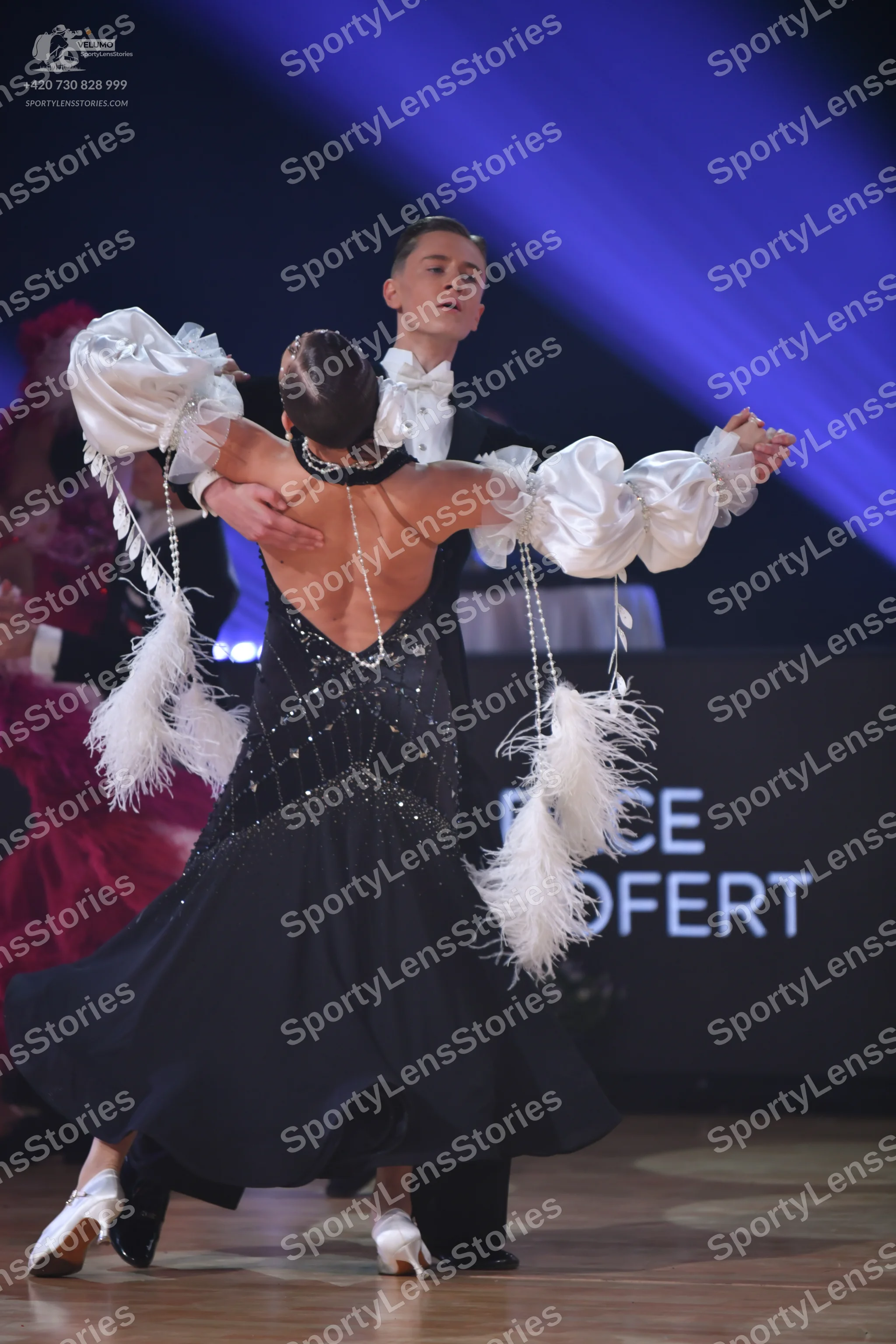 Dancesport competitor: Female dancer: black ballroom gown with a sequined/beaded bodice, deep V-back, a