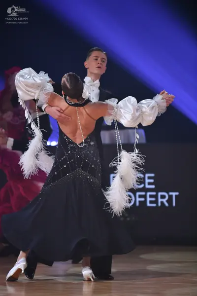 Dancesport competitor: Female dancer: black ballroom gown with a sequined/beaded bodice, deep V-back, a