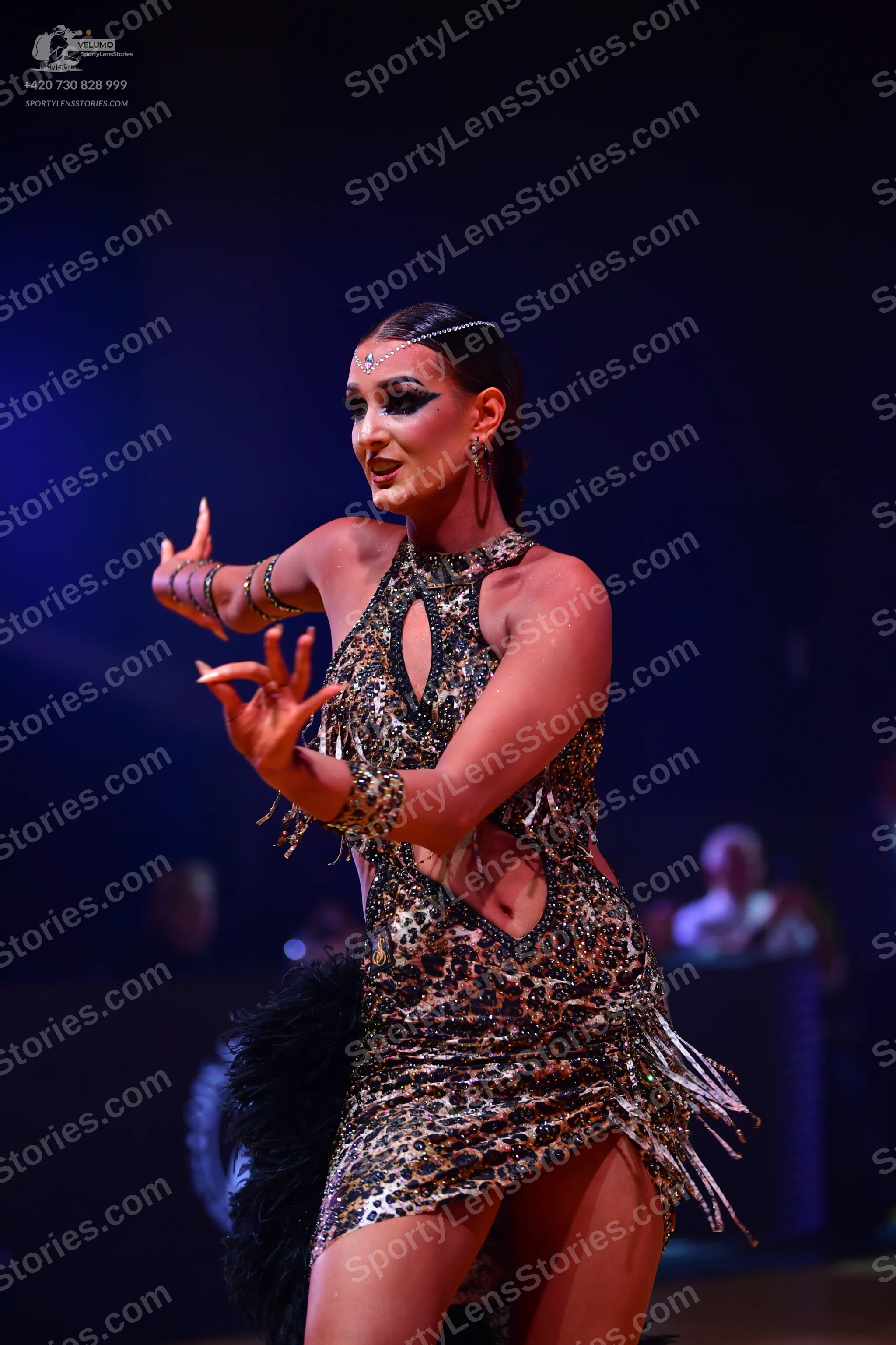Dancesport competitor: Female dancer: leopard print Latin dress with cutouts, sequins, and fringe, pair