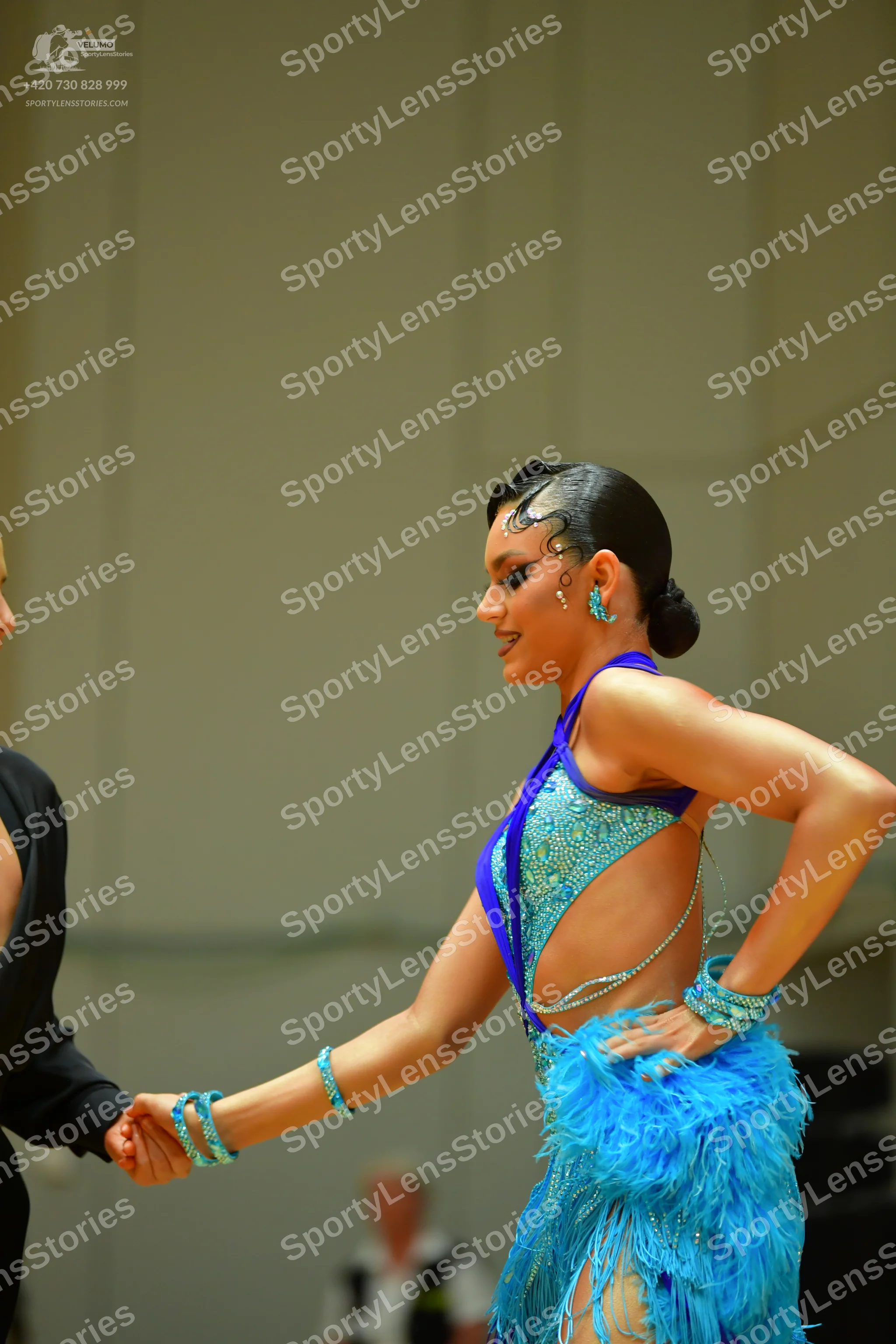 Dancesport competitor: Female dancer: bright blue sequined latin dress with fringe and matching turquoi