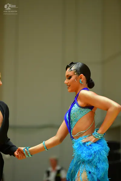 Dancesport competitor: Female dancer: bright blue sequined latin dress with fringe and matching turquoi