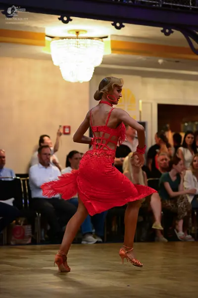 Dancesport competitor: Female dancer: red Latin dress with a lace-patterned bodice and a fringe skirt, 