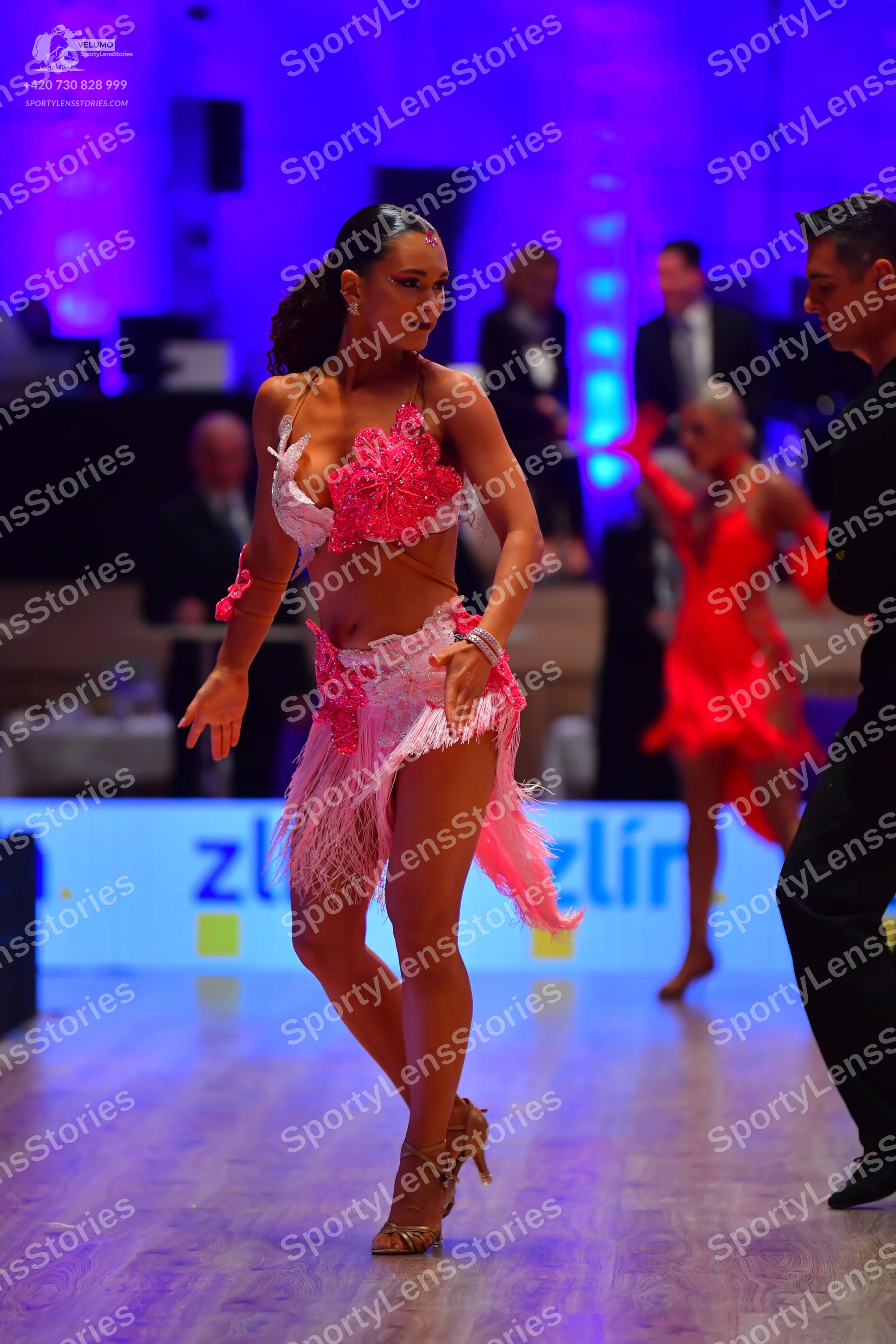 Dancesport competitor: Female dancer in foreground: pink latin dress with a lace/sequin top and a fring