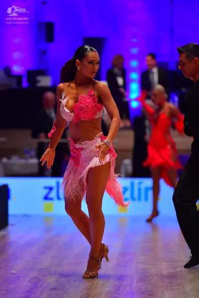 Dancesport competitor: Female dancer in foreground: pink latin dress with a lace/sequin top and a fring