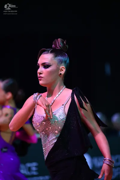 Dancesport competitor: Female dancer in foreground: silver sequined Latin dress with a black asymmetric