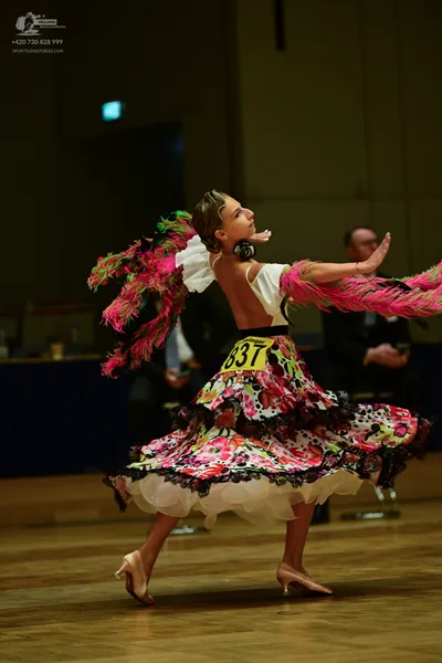 Dancesport competitor #837: ** Female: The dancer is wearing a vibrant, voluminous skirt in a swirling patte