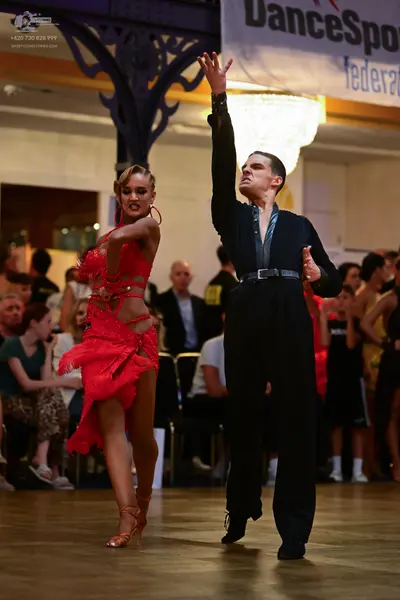 Dancesport competitor: Male dancer: black long-sleeved dance top and trousers with a satin-like panel o