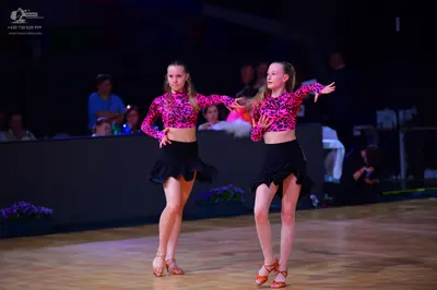 Dancesport competitor: Female dancers: matching long-sleeved tops with a pink and black leopard-style p