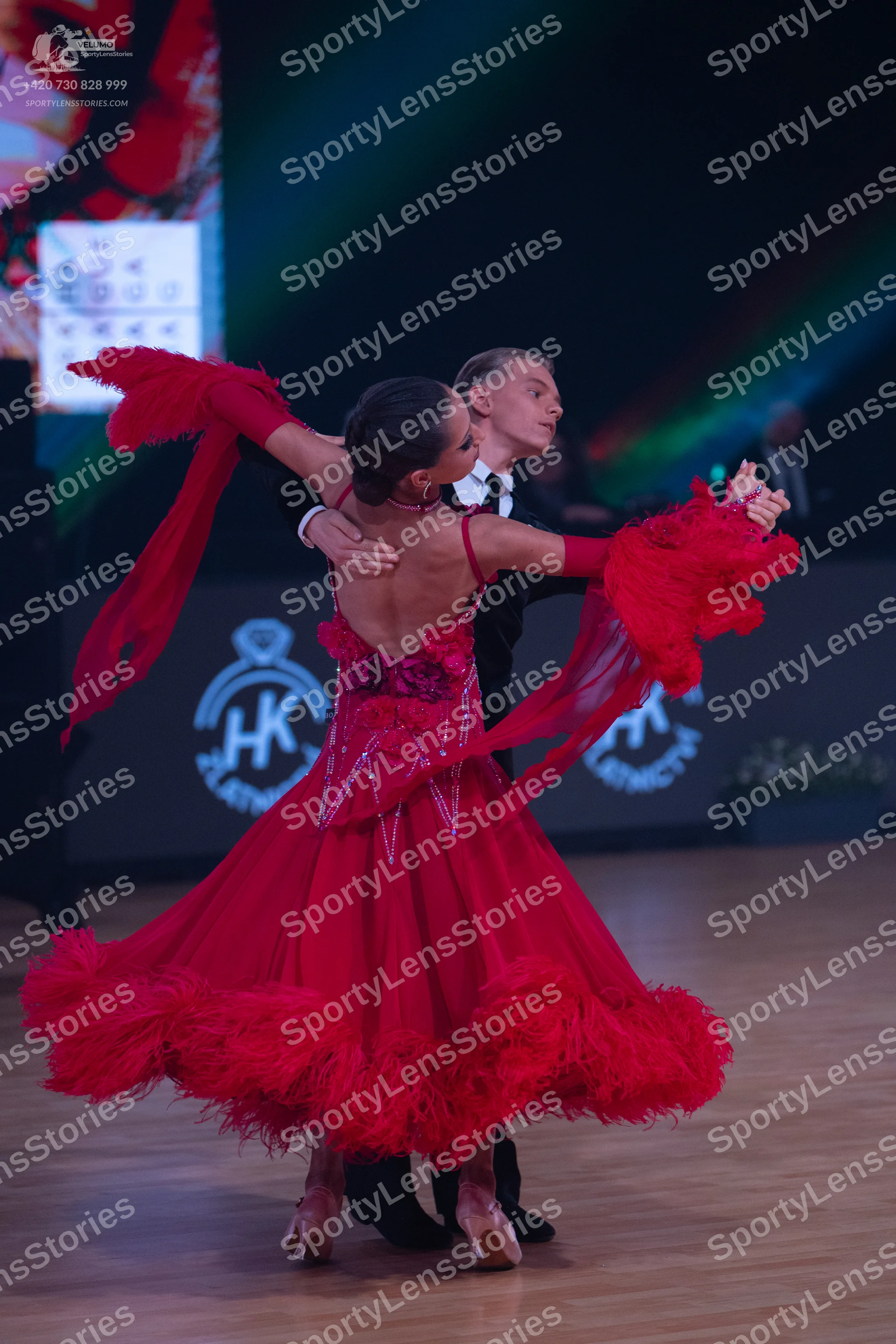 Dancesport competitor: Female dancer: red Latin dance dress with a sequined bodice and large, voluminou