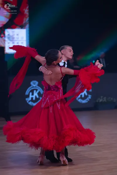 Dancesport competitor: Female dancer: red Latin dance dress with a sequined bodice and large, voluminou