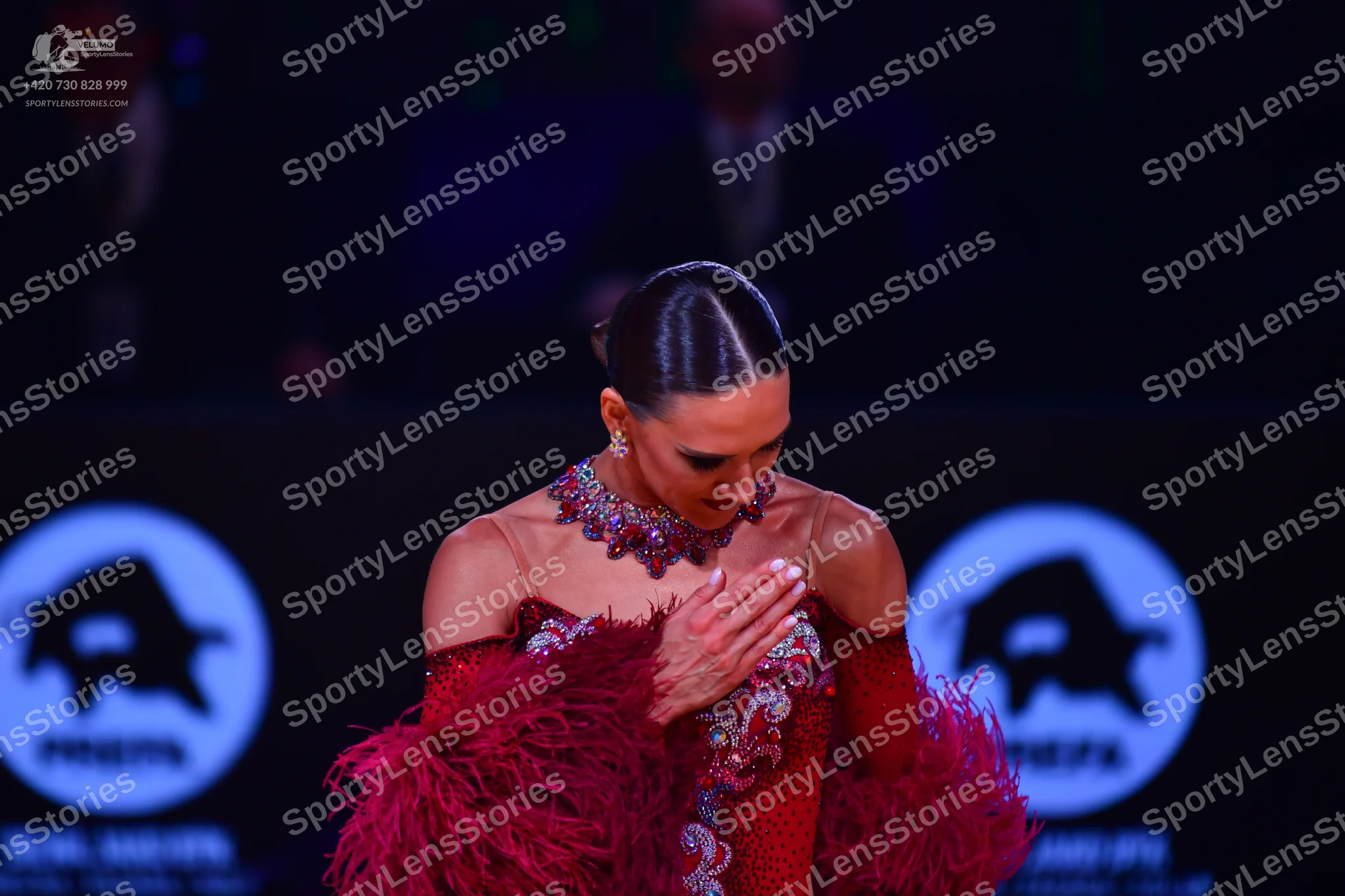 Dancesport competitor: Female dancer: red/maroon Latin-style dress with heavy sequin and bead embellish