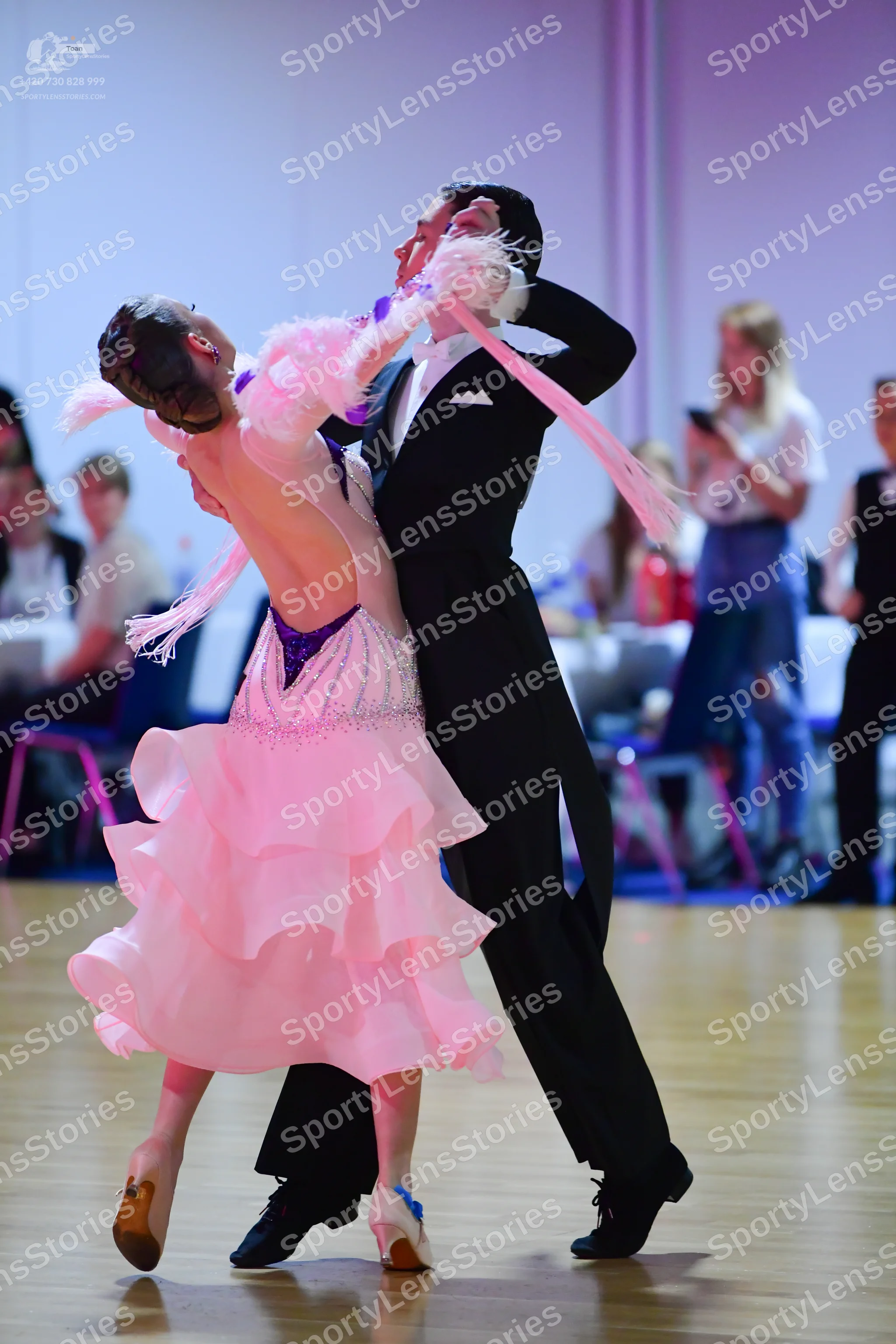Dancesport competitor: Female dancer: white/pale pink ballroom dress with a ruffled skirt, featuring pu