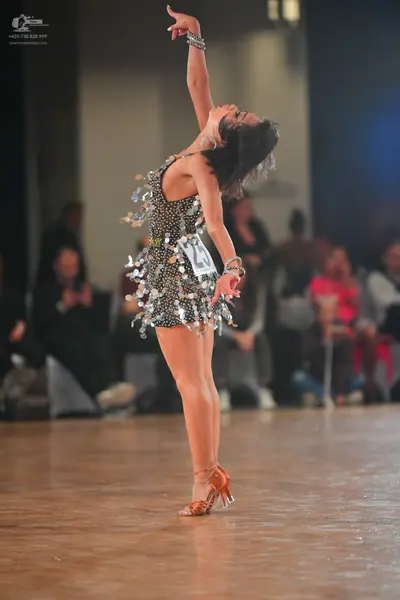 Dancesport competitor: Female dancer: black sequined Latin dance dress with large silver paillettes and