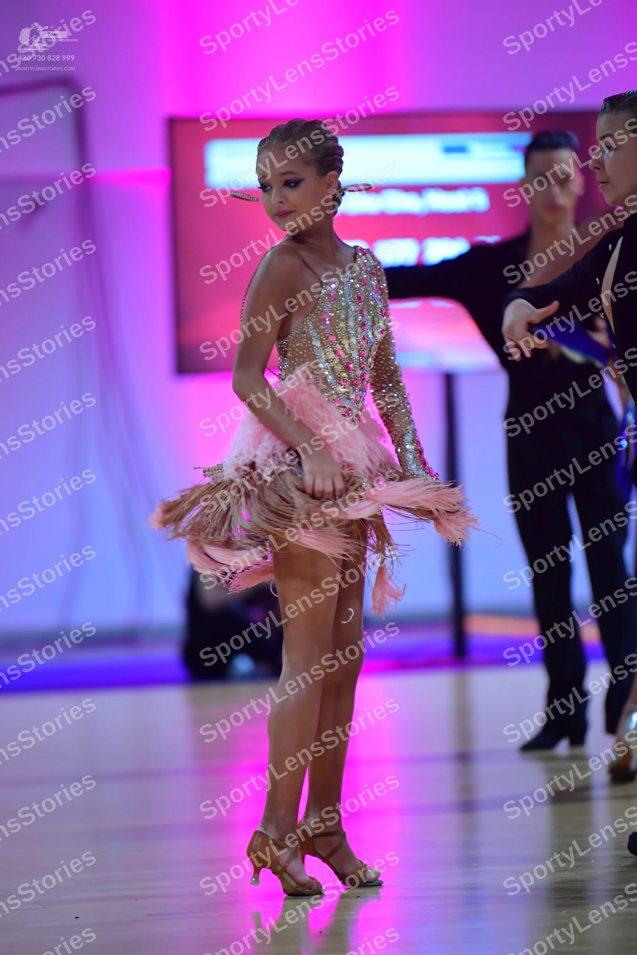 Dancesport competitor: Female dancer: champagne-colored Latin dress with long sleeves, heavily embellis