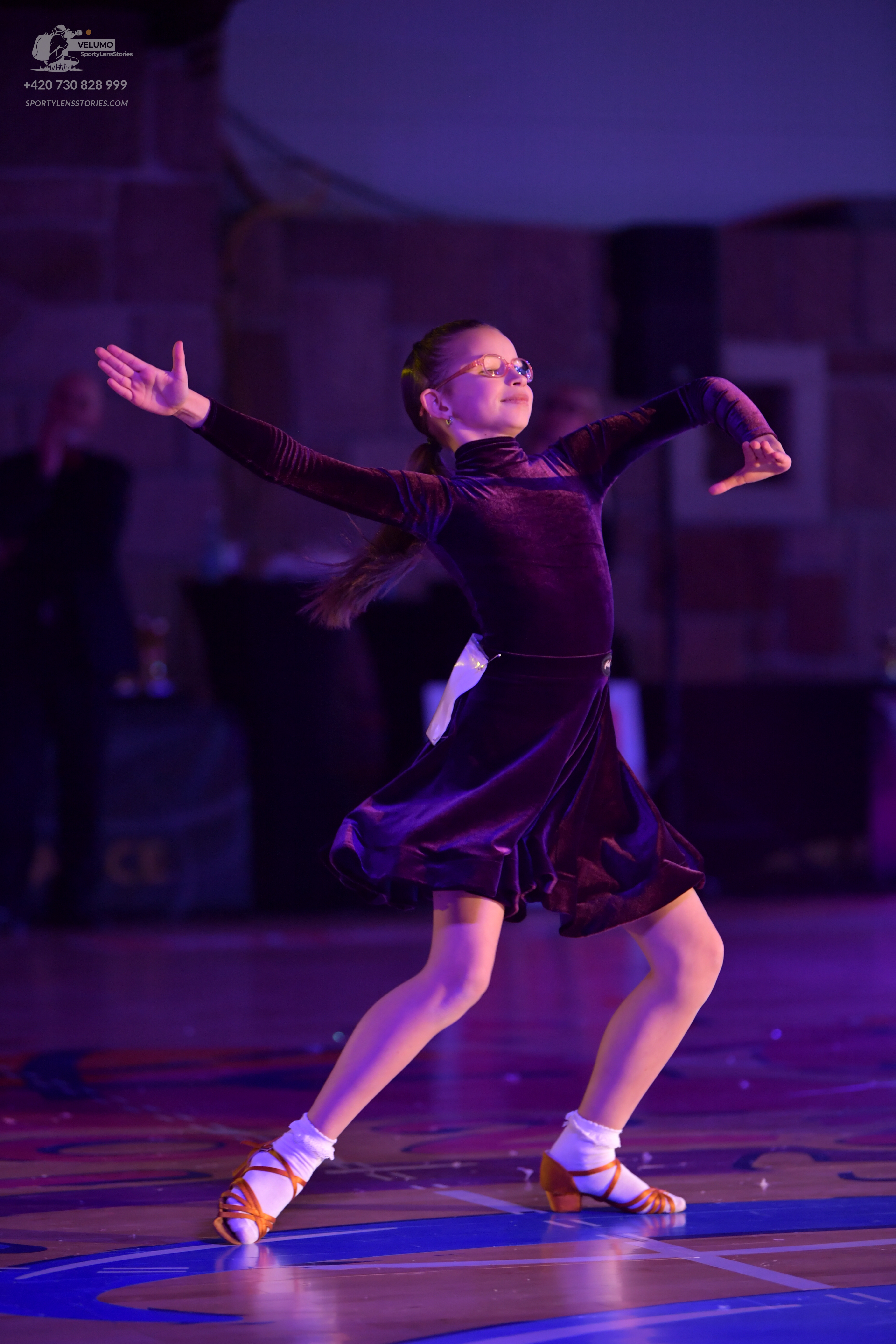 Dancesport competitor: Female dancer: dark purple long-sleeved satin Latin dance dress with a flared sk