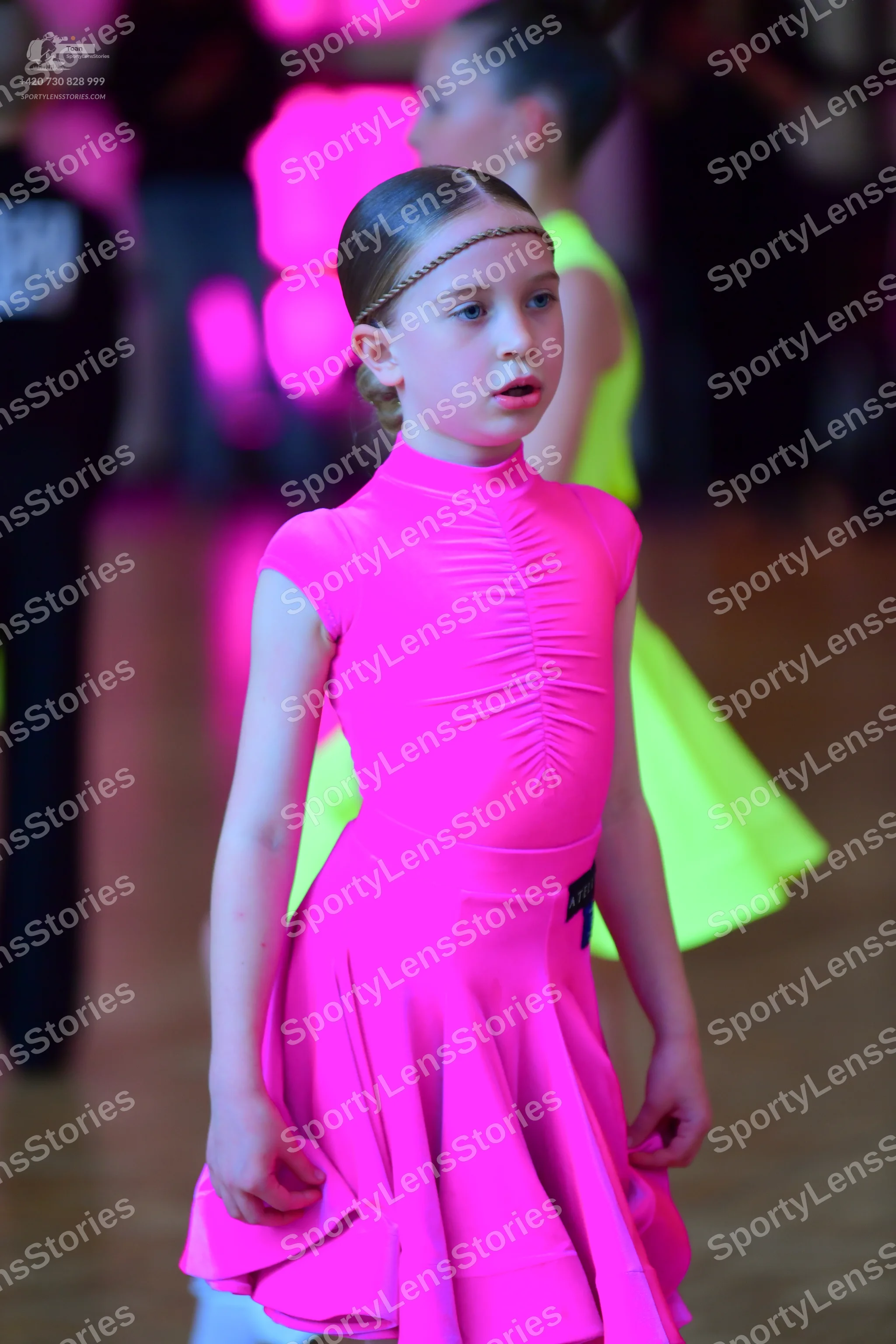 Dancesport competitor: Female dancer: bright pink, short-sleeved, high-neck dress with a ruched bodice 