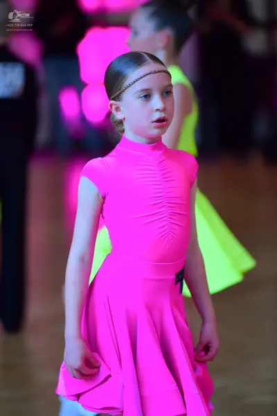 Dancesport competitor: Female dancer: bright pink, short-sleeved, high-neck dress with a ruched bodice 