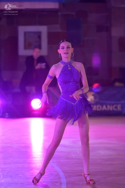 Dancesport competitor: Female dancer: purple Latin dance dress with a halter neckline, a sequined/rhine