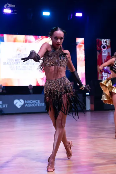 Dancesport competitor: Main female dancer: a two-piece dark brown and gold Latin dance costume consisti