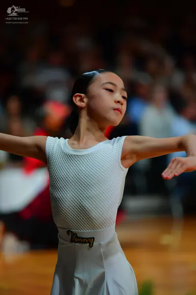 Dancesport competitor: Female dancer: white sleeveless top with a textured pattern and a matching white