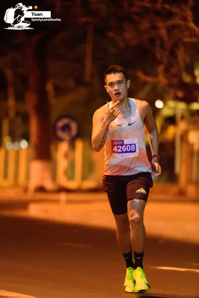 Marathon runner #42608: Runner 1: white patterned tank top, black shorts, black socks, bright yellow/lim