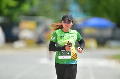 Marathon runner #5367: Runner 1: green jersey, black long-sleeved shirt, black shorts, black cap, sungl