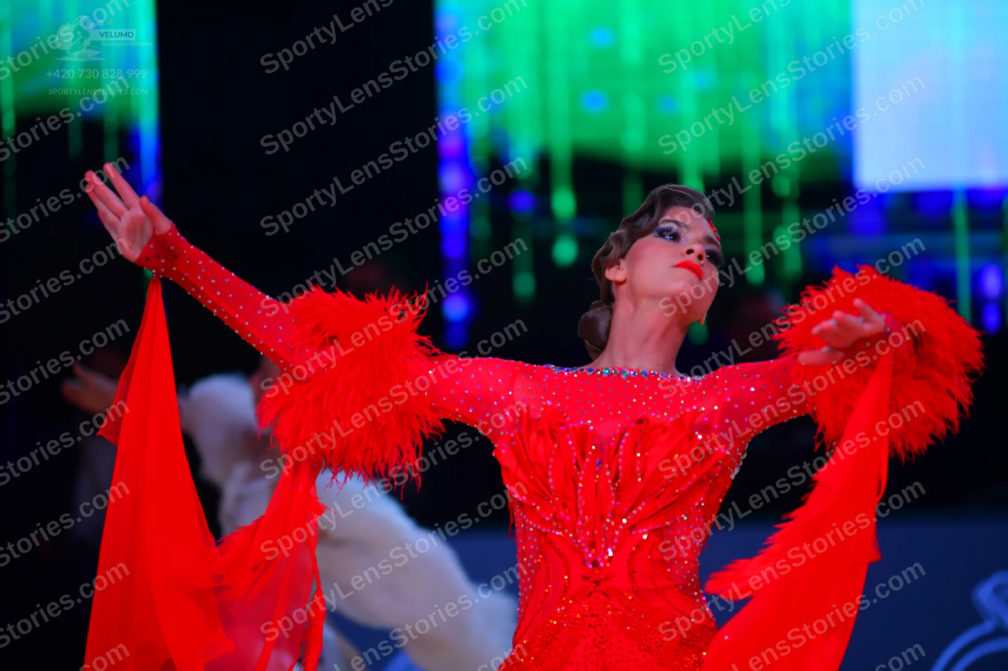 Dancesport competitor: Female dancer: red latin dress with sequins and large red feather/fringe details