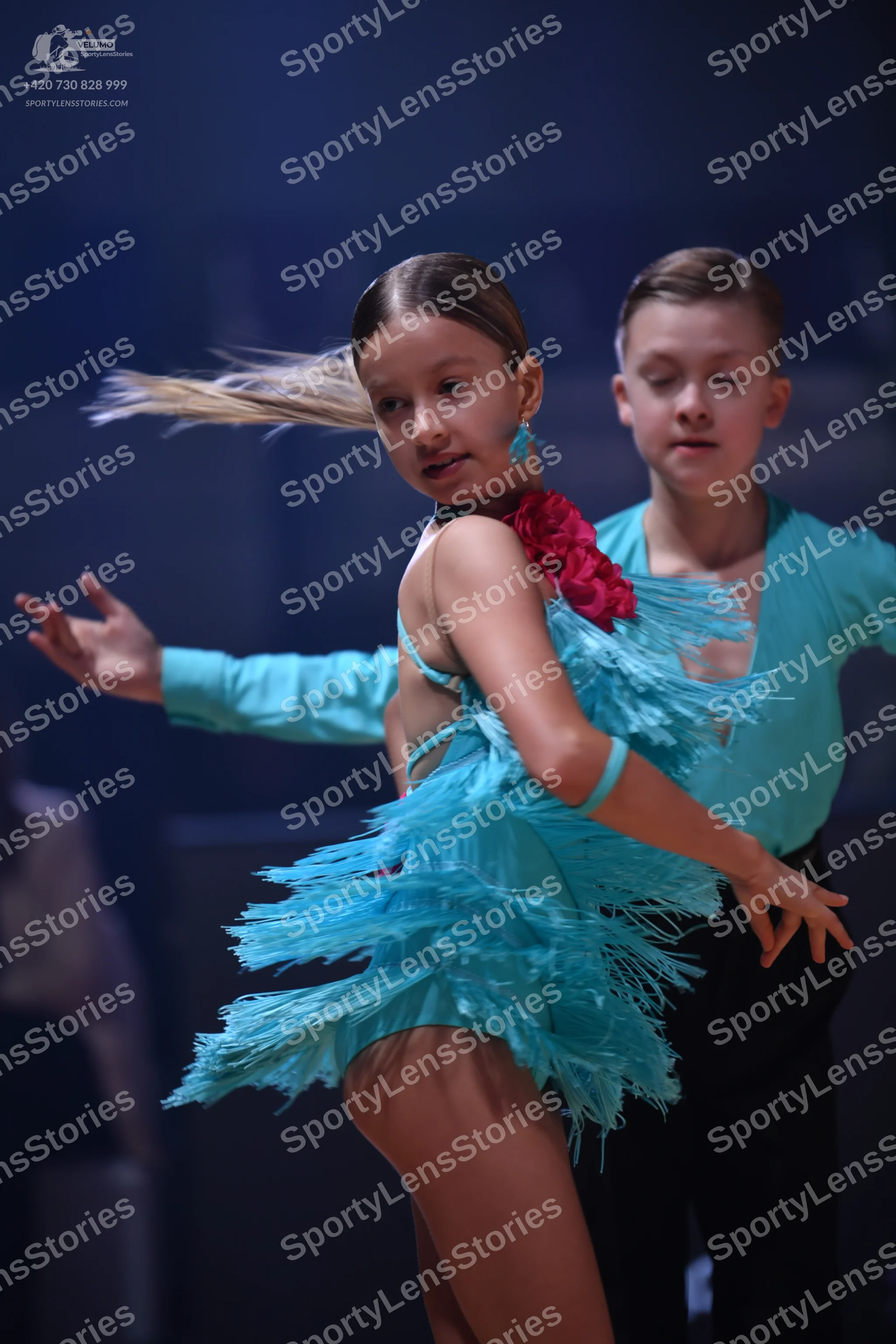 Dancesport competitor: Female dancer: teal latin dress with long fringe and teal earrings