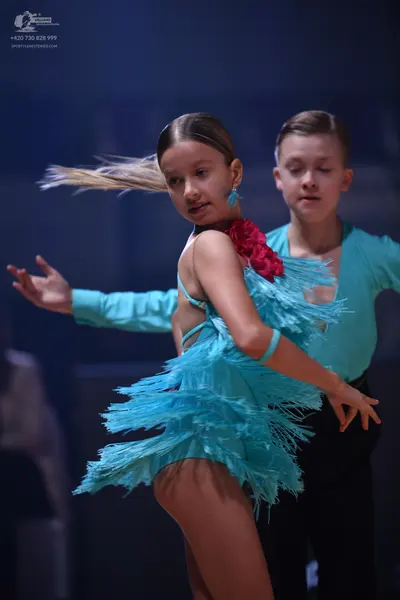 Dancesport competitor: Female dancer: teal latin dress with long fringe and teal earrings